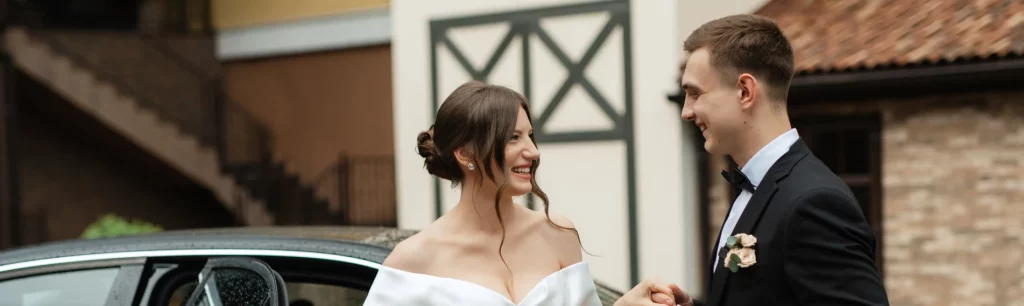 Luxury wedding coach hire outside a historic Manchester venue, guests boarding with smiles. Special event coach hire