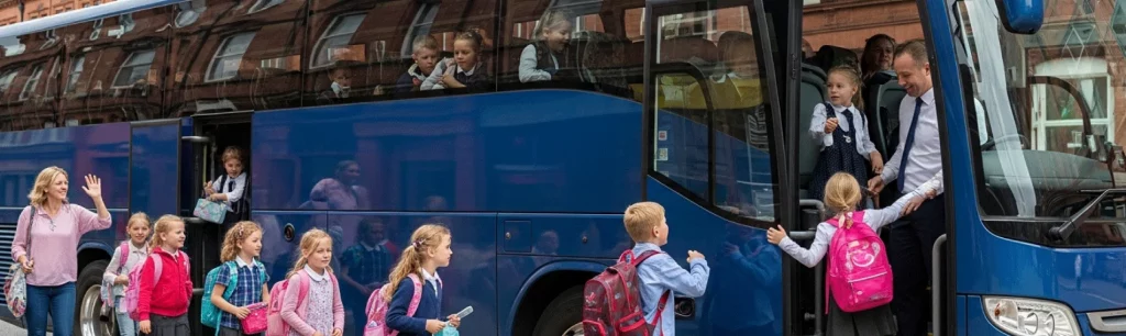 Children boarding a Manchester Coach Company vehicle for a school-holiday trip